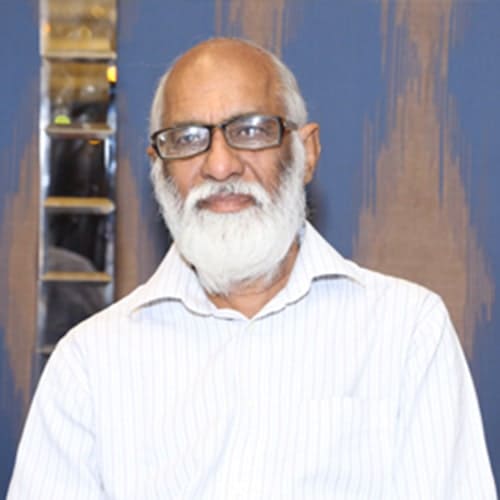 A man with glasses and white beard in a white shirt 