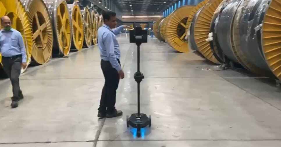 A man standing next to a machine in a factory.